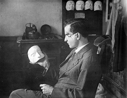 A wounded soldier examining the beginnings of his facial mask (image: The Imperial War Museum). 